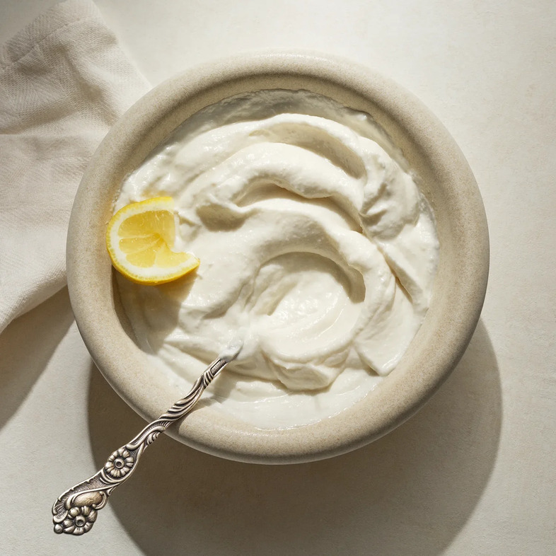 Toum, krämig libanesisk vitlöksröra med citron och olja, serverad som smakrikt tillbehör.